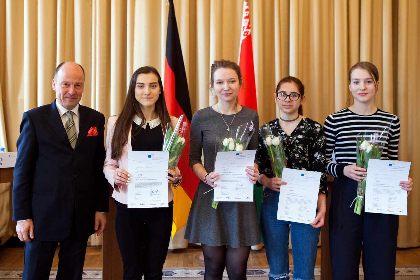 JDI Entwickler Ansgar Kemmann Gewinnerin Anastasiya Mankevich und Hanna Skrypko von links mit Teilnehmerinnen Foto Viktoryia Kharytonava Jugend debattiert international